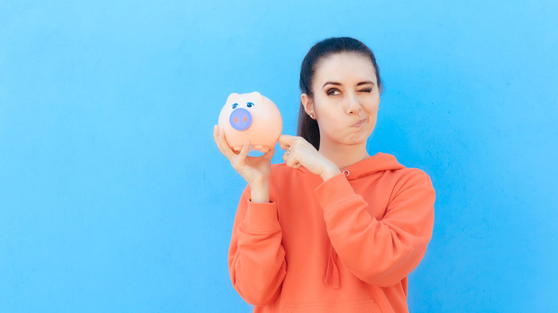 Eine junge Frau checkt ihr Sparschwein (Symbolbild): Gerade weil Frauen im Schnitt weniger Geld verdienen, sollten sie sich umso mehr mit ihren Finanzen beschäftigen.