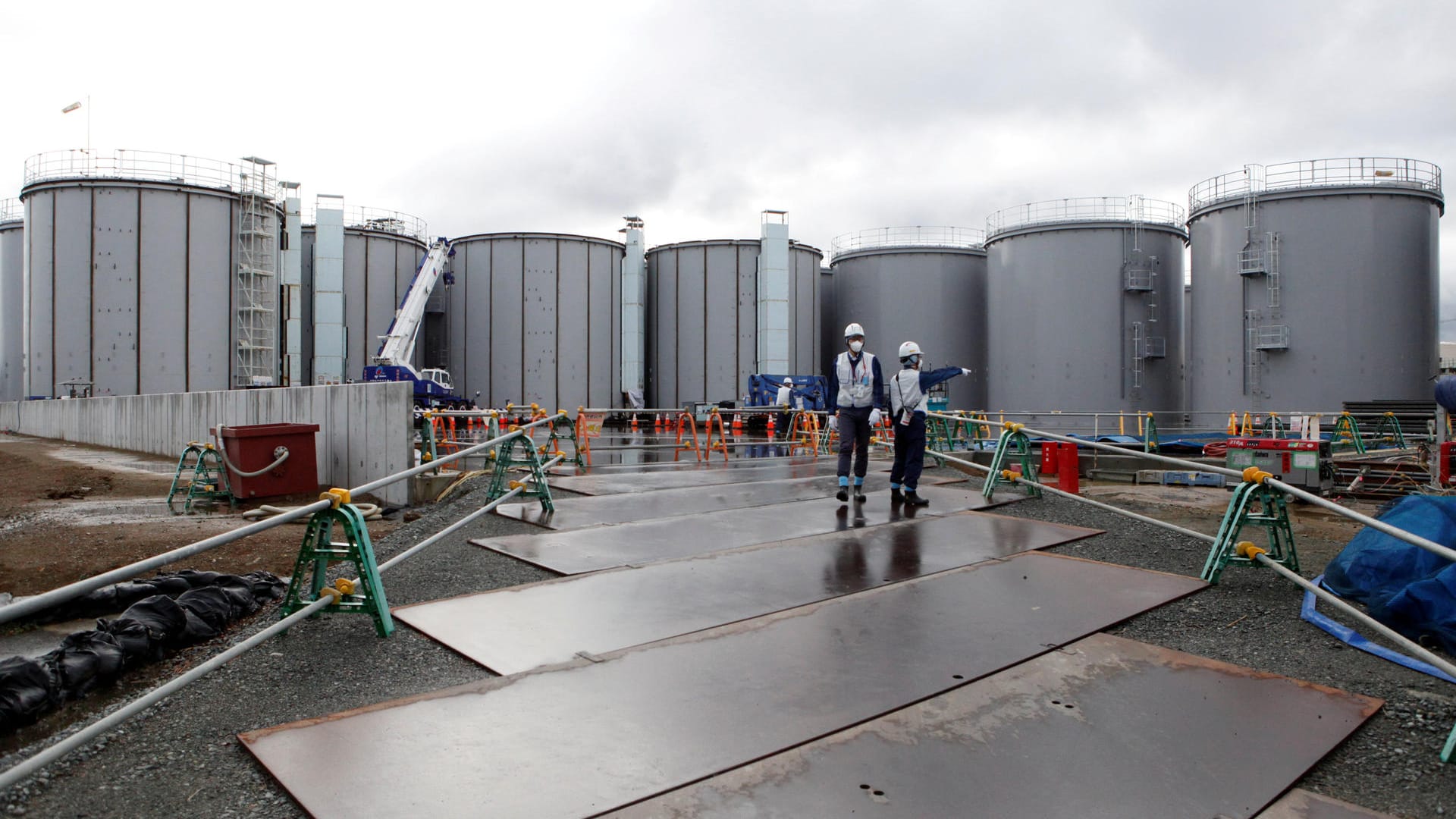 Arbeiter stehen bei den Wassertanks: Der Lagerplatz für das verstrahlte Wasser wird knapp.