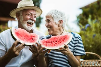 Paar genießt eine Wassermelone: Es braucht nicht immer Vitaminpräparate – Man kann viele Vitamine auch über Obst und Gemüse aufnehmen.