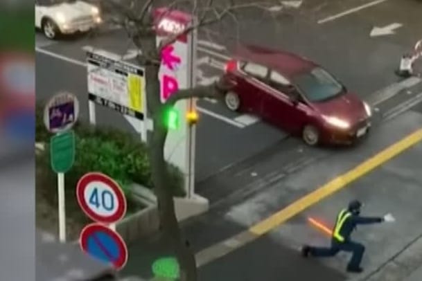 Verkehr regeln mal anders: Mit einer unterhaltsamen Tanzperformance und einem Lichtschwert begeistert ein Polizist die Verkehrsteilnehmer.