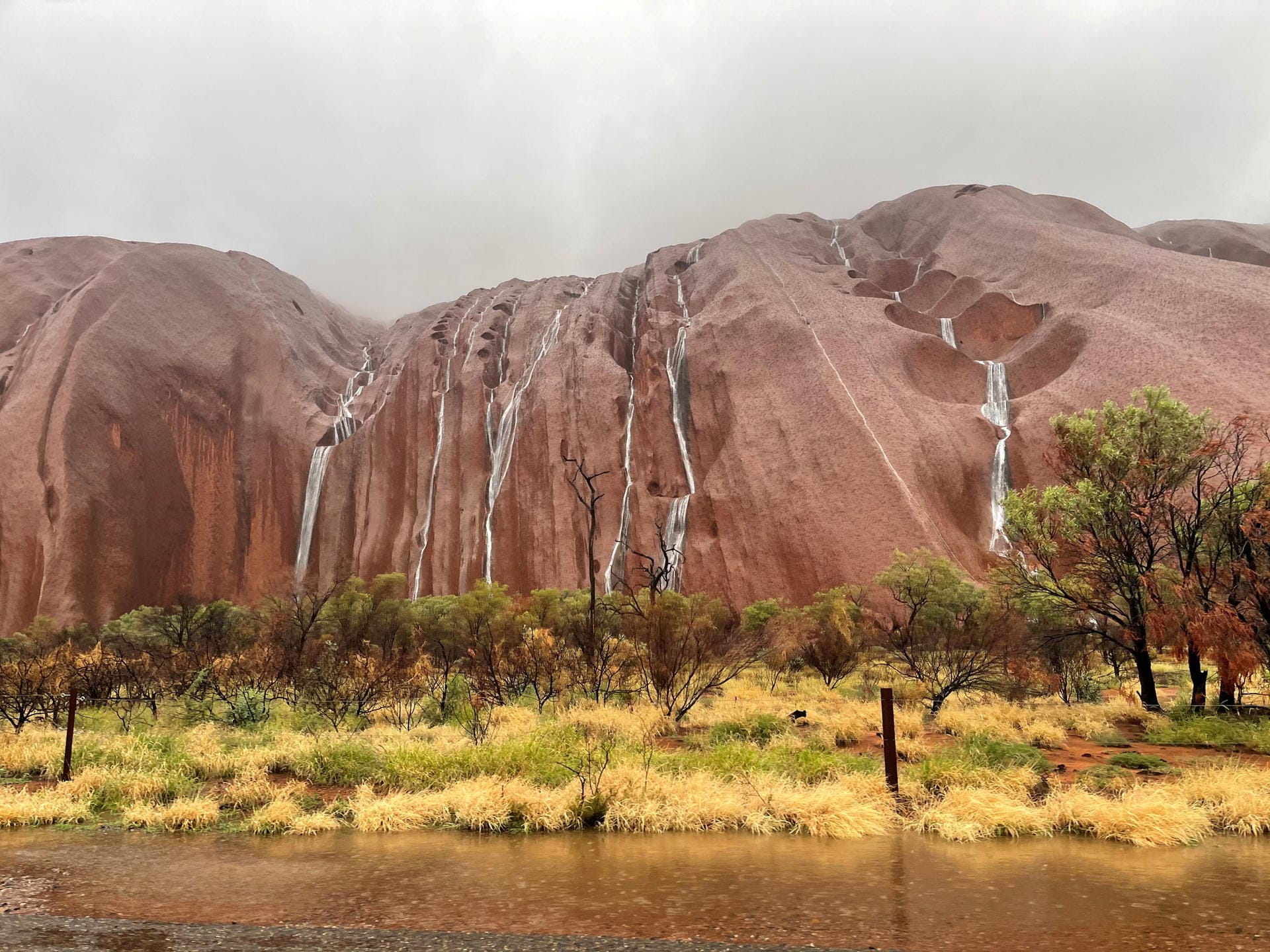 Waterfalls tumble over the surface of Uluru in the Northern Territory, Australia