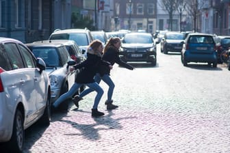 Zwei Kinder rennen über eine Straße (Symbolbild): Ein 13-Jähriger wollte die Ampel überqueren und wurde von einem Auto erfasst.