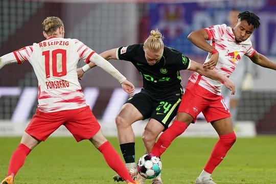 Wolfsburgs Xaver Schlager (M) im Zweikampf mit den Leipzigern Christopher Nkunku (r) und Emil Forsberg.