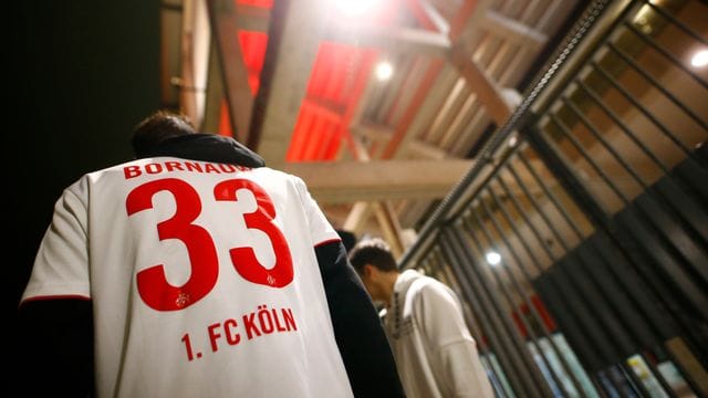 Kölner Fans stehen außerhalb des Stadions. Kölner Fans stehen außerhalb des Stadions.