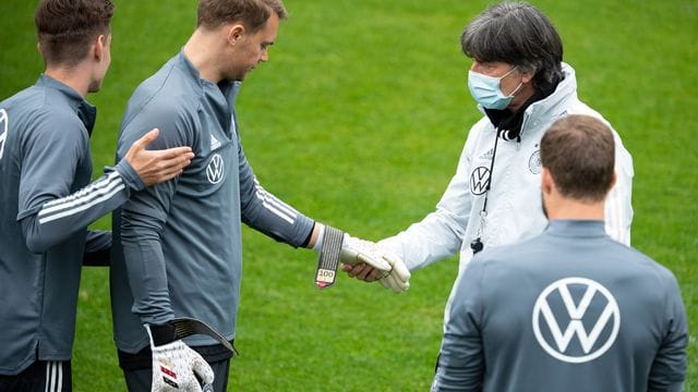 Manuel Neuer zeigt Bundestrainer Joachim Löw die Torwarthandschuhe für sein 100. Manuel Neuer zeigt Bundestrainer Joachim Löw die Torwarthandschuhe für sein 100.