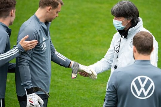 Manuel Neuer zeigt Bundestrainer Joachim Löw die Torwarthandschuhe für sein 100.