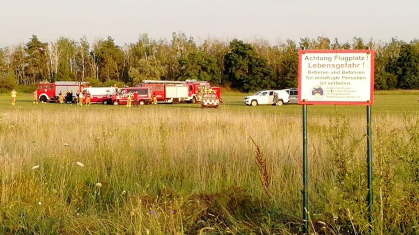 Die Feuerwehr steht am Flugplatz Renneritz an der weiträumig abgesperrten Unfallstelle.