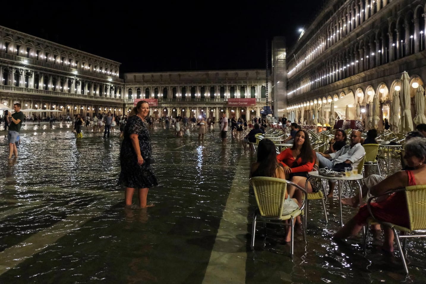 People sit at a cafe in a flooded St. Mark's Square during an exceptional high water in Venice