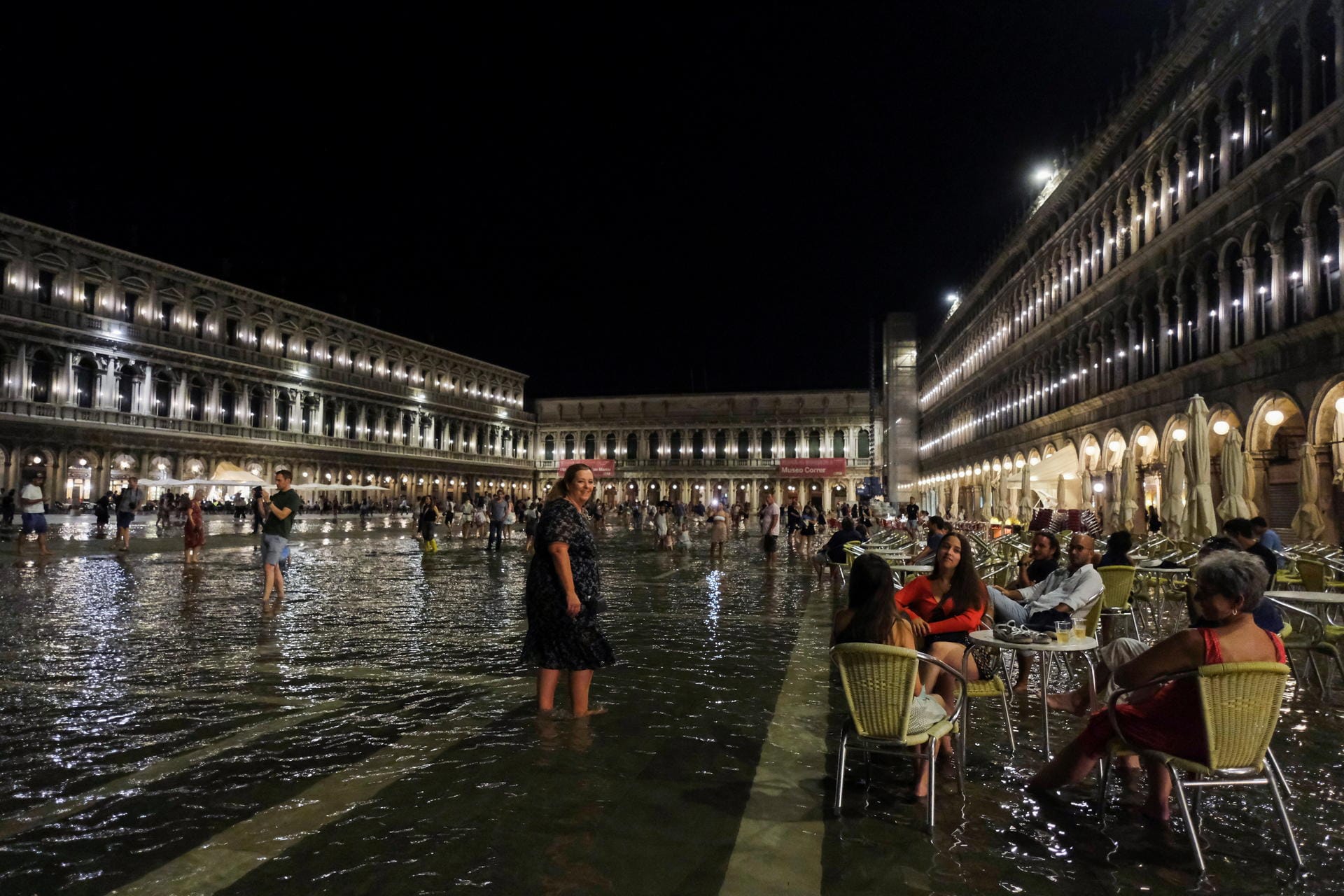 People sit at a cafe in a flooded St. Mark's Square during an exceptional high water in Venice