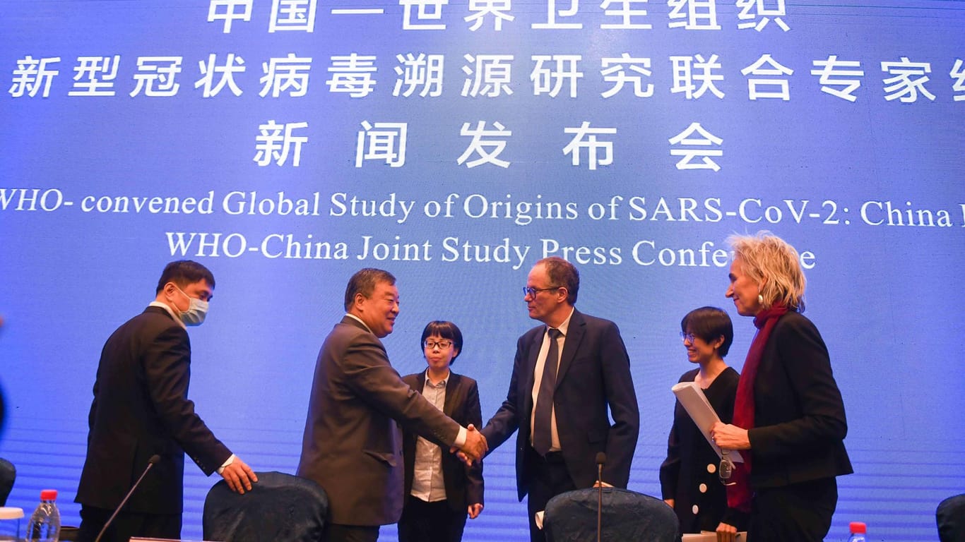 Schwierige Gespräche: Peter Embarek schüttelt in Wuhan am Rande einer Pressekonferenz beim Besuch der Untersuchungsgruppe Hände mit dem chinesischen Wissenschaftler Liang Wannian.