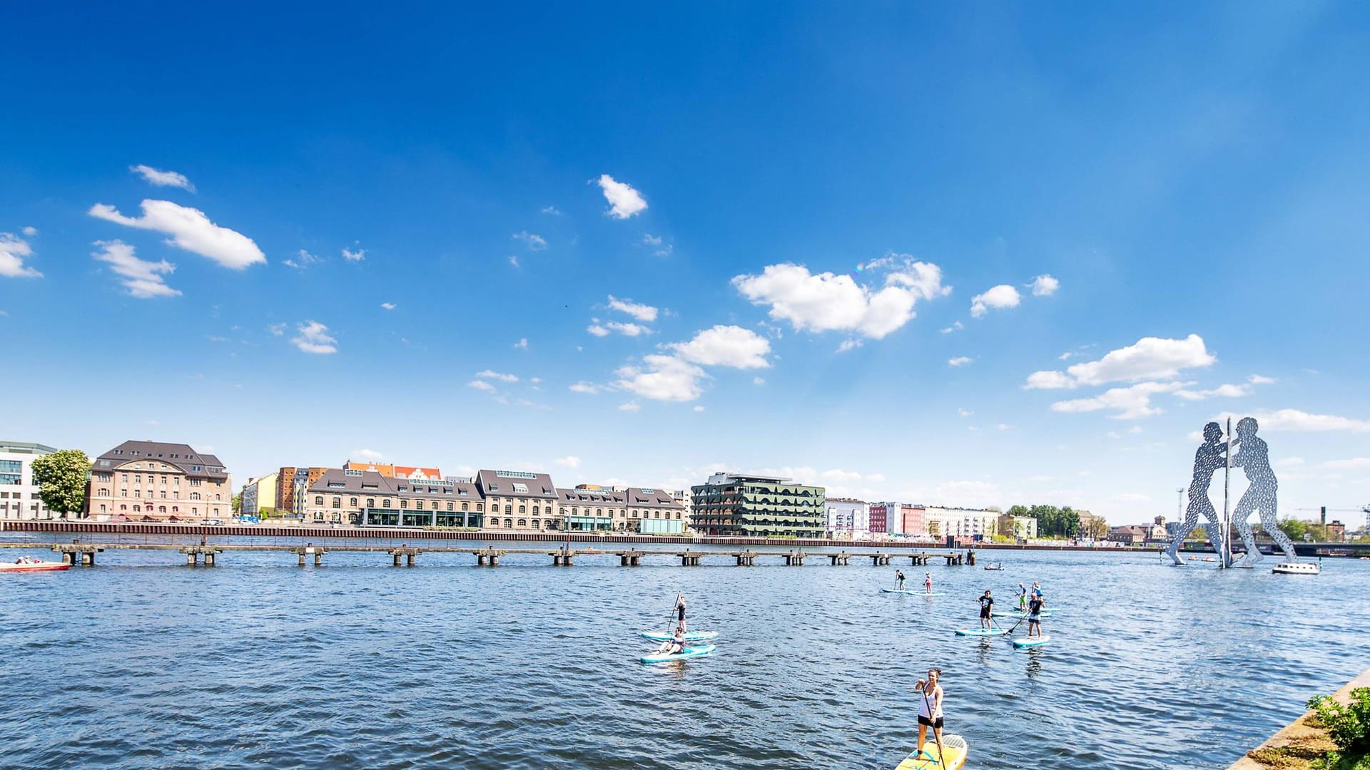 Mehrere SUPs auf der Spree: Im Hintergrund sieht man die Molecule Men.