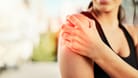 Eine Frau greift sich an die Schulter: Verspannungen im Schulterbereich können die Beweglichkeit stark einschränken. In vielen Fällen helfen regelmäßige Trainingsübungen.