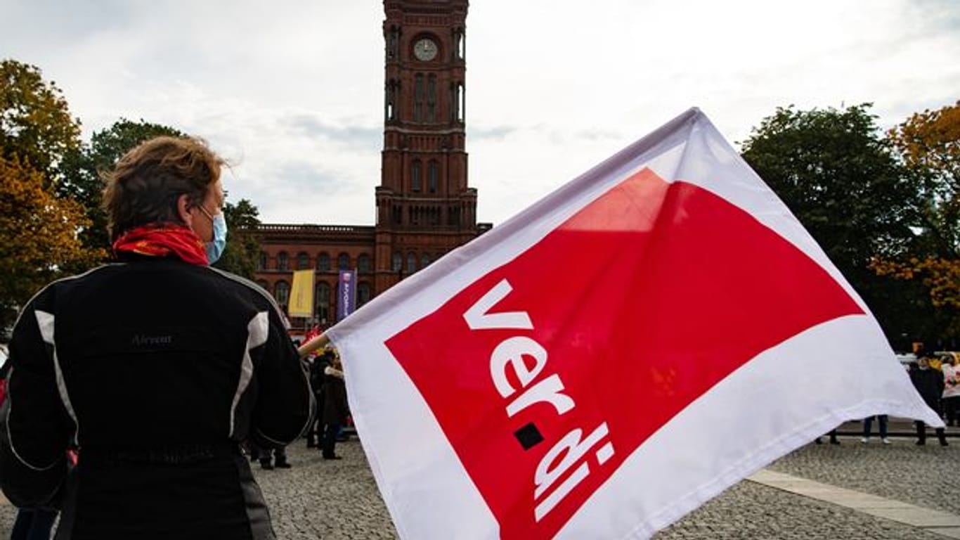 Person mit Verdi-Flagge in Berlin (Symbolbild): Die Gewerkschaften wollen einen Ausgleich für die Belastungen der Beschäftigten in der Pandemie herausholen.