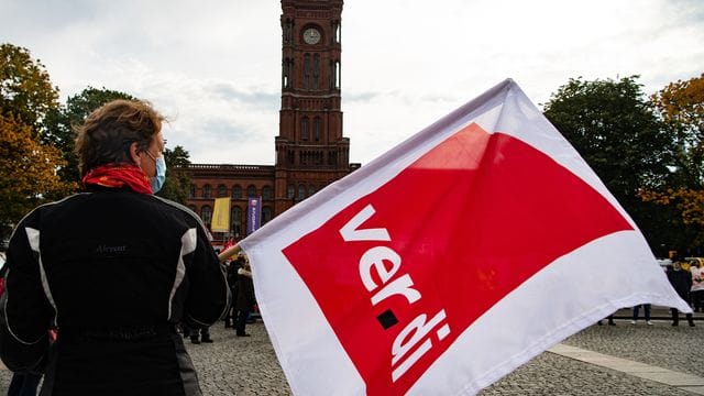 Person mit Verdi-Flagge in Berlin (Symbolbild): Die Gewerkschaften wollen einen Ausgleich für die Belastungen der Beschäftigten in der Pandemie herausholen.