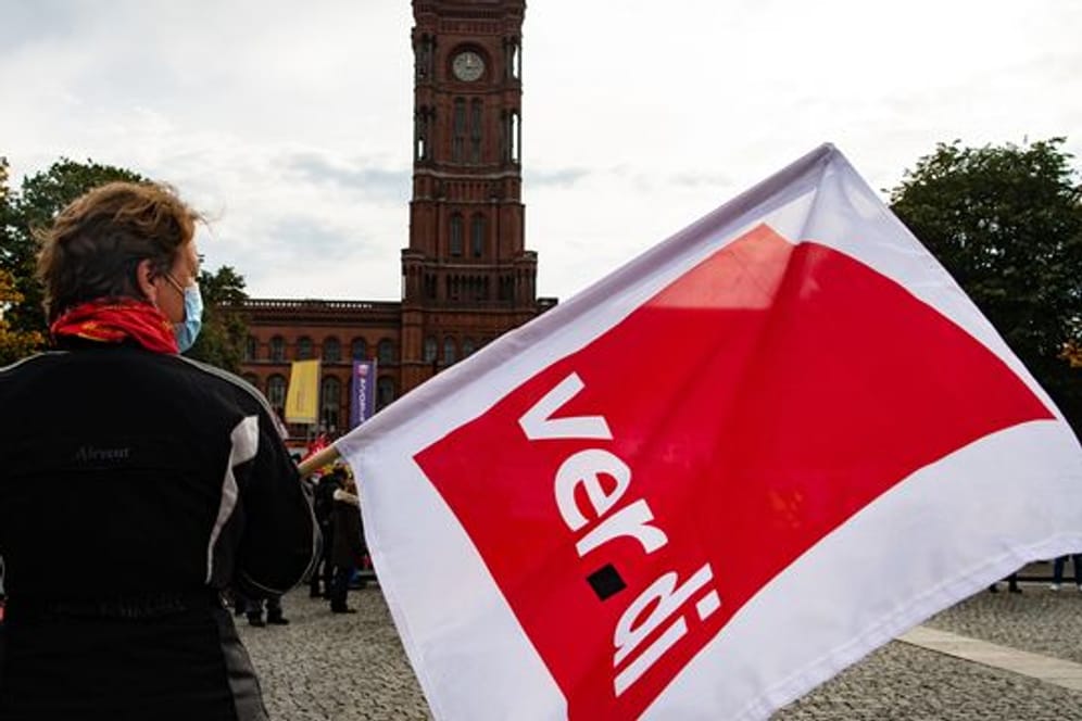 Person mit Verdi-Flagge in Berlin (Symbolbild): Die Gewerkschaften wollen einen Ausgleich für die Belastungen der Beschäftigten in der Pandemie herausholen.