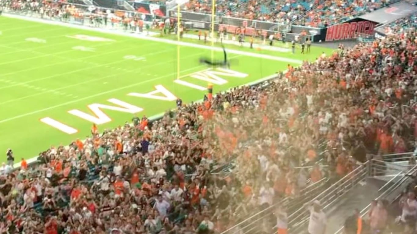 Fans use the U.S. flag to catch a falling cat at Hard Rock Stadium, in Miami Gardens
