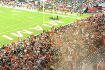 Fans use the U.S. flag to catch a falling cat at Hard Rock Stadium, in Miami Gardens