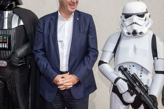 Markus Söder (M), CSU-Parteivorsitzender und Ministerpräsident von Bayern, steht zwischen Akteuren, die verkleidet als Figuren aus dem Film "Star Wars" sind: Das Museum stellt Zukunftsthemen vor und diskutiert ethische Fragen.