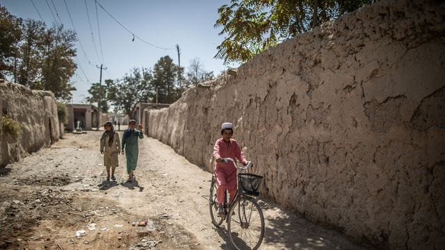 Ein afghanischer Junge fährt in Isa Khel außerhalb von Kundus Fahrrad.