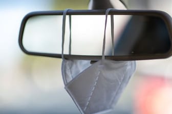 Infektionsschutz im Auto: Eine FFP2-Maske hängt an einem Rückspiegel (Symbolbild).
