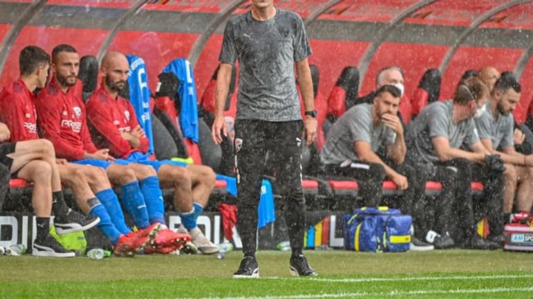 Trainer Roberto Pätzold steht am Spielfeldrand im Regen.