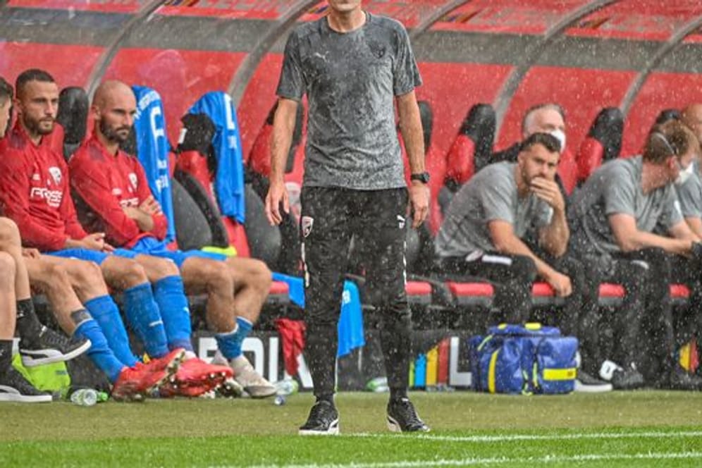 Trainer Roberto Pätzold steht am Spielfeldrand im Regen.