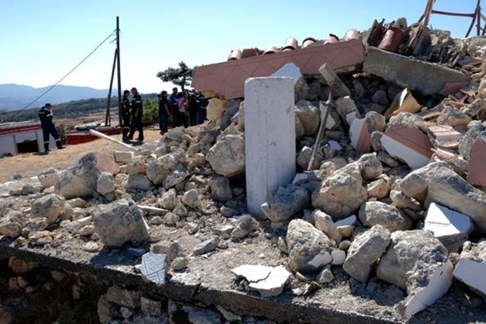 Feuerwehrleute stehen neben einer zerstörten Kirche im Süden der Insel Kreta.