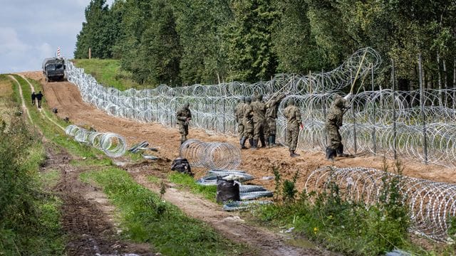 Polnische Soldaten errichten einen Stacheldrahtzaun Grenze zu Belarus (Archiv).