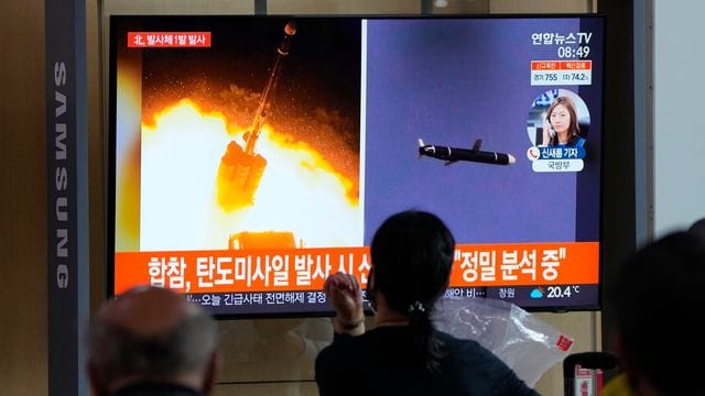 Menschen im im Seouler Bahnhof sehen während einer Nachrichtensendung ein Fernsehbild des nordkoreanischen Raketenstarts.