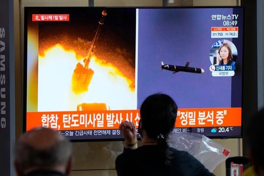 Menschen im im Seouler Bahnhof sehen während einer Nachrichtensendung ein Fernsehbild des nordkoreanischen Raketenstarts.