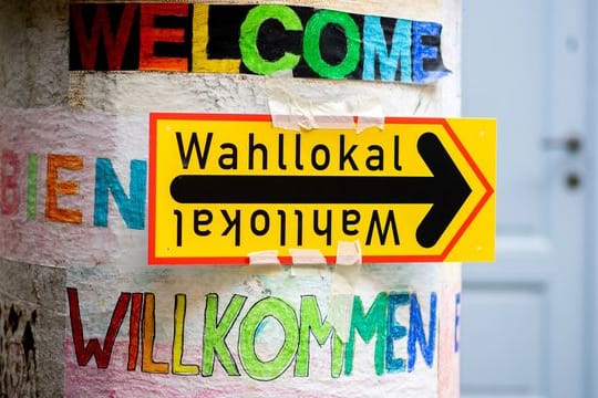 Ein Schild weist im Berliner Stadtteil Prenzlauer Berg den Weg zu einem Wahllokal.