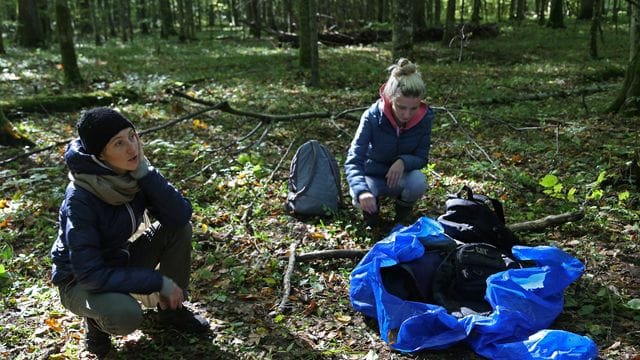Maria Zlonkiewicz (l) und Aleksandra Gubinska knien nahe der polnisch-belarussischen Grenze neben Gegenständen, die von Flüchtlingen zurückgelassen wurden. Maria Zlonkiewicz (l) und Aleksandra Gubinska knien nahe der polnisch-belarussischen Grenze neben Gegenständen, die von Flüchtlingen zurückgelassen wurden.