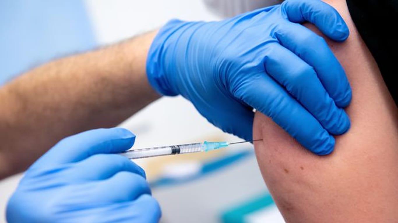 Ein Mitarbeiter der Asklepios Klinik wird von einem Kollegen mit dem Corona-Impfstoff von Biontech/Pfizer geimpft.