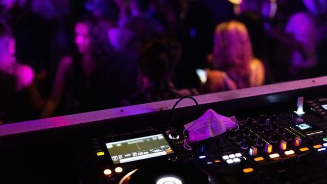 Eine Maske liegt auf einem Mischpult in einem Club.