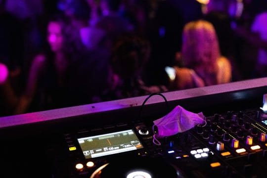 Eine Maske liegt auf einem Mischpult in einem Club.
