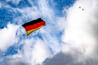 Über dem Flughafen Paderborn-Lippstadt hissen sieben Fallschirmspringer eine Flagge, die so groß ist wie niemals zuvor bei einem Sprung.