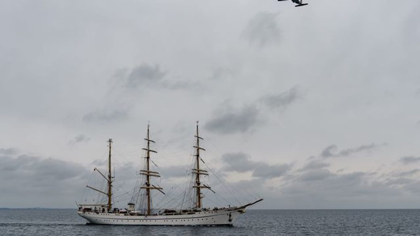 Das Segelschulschiff "Gorch Fock" fährt auf die Kieler Förde zu, während eine Transall der Bundeswehr das Schiff überfliegt.