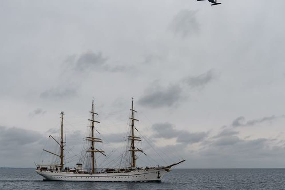 Das Segelschulschiff "Gorch Fock" fährt auf die Kieler Förde zu, während eine Transall der Bundeswehr das Schiff überfliegt.
