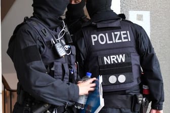 Polizisten durchsuchen ein Gebäude in Düsseldorf beim landesweiten Polizeieinsatz gegen Geldwäsche und Terrorfinanzierung.
