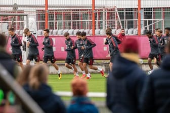 Nach langer Zeit wieder ein öffentliches Training: Spieler und Trainer des FC Bayern München laufen sich vor anwesenden Fans warm.
