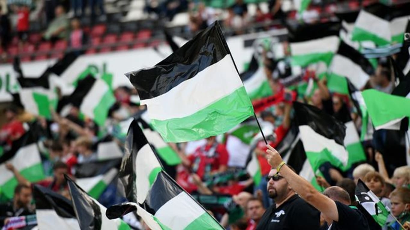 Hannover 96 hofft auf ein wieder voll ausgelastetes Stadion: Fans schwenken Fahnen.