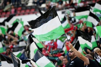 Hannover 96 hofft auf ein wieder voll ausgelastetes Stadion: Fans schwenken Fahnen.