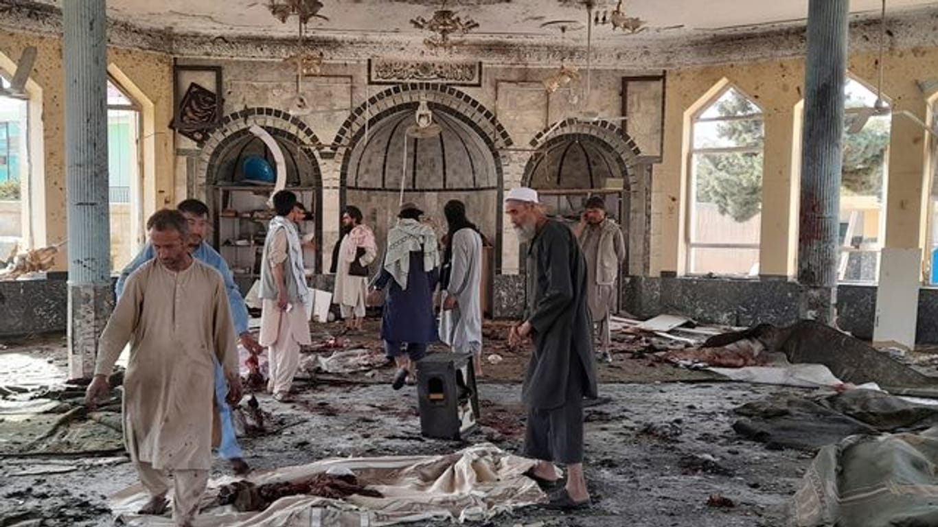 Menschen betrachten die Schäden in der attackierten Moschee in Kundus.