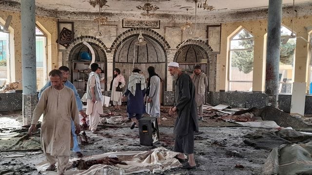 Menschen betrachten die Schäden in der attackierten Moschee in Kundus. Menschen betrachten die Schäden in der attackierten Moschee in Kundus.