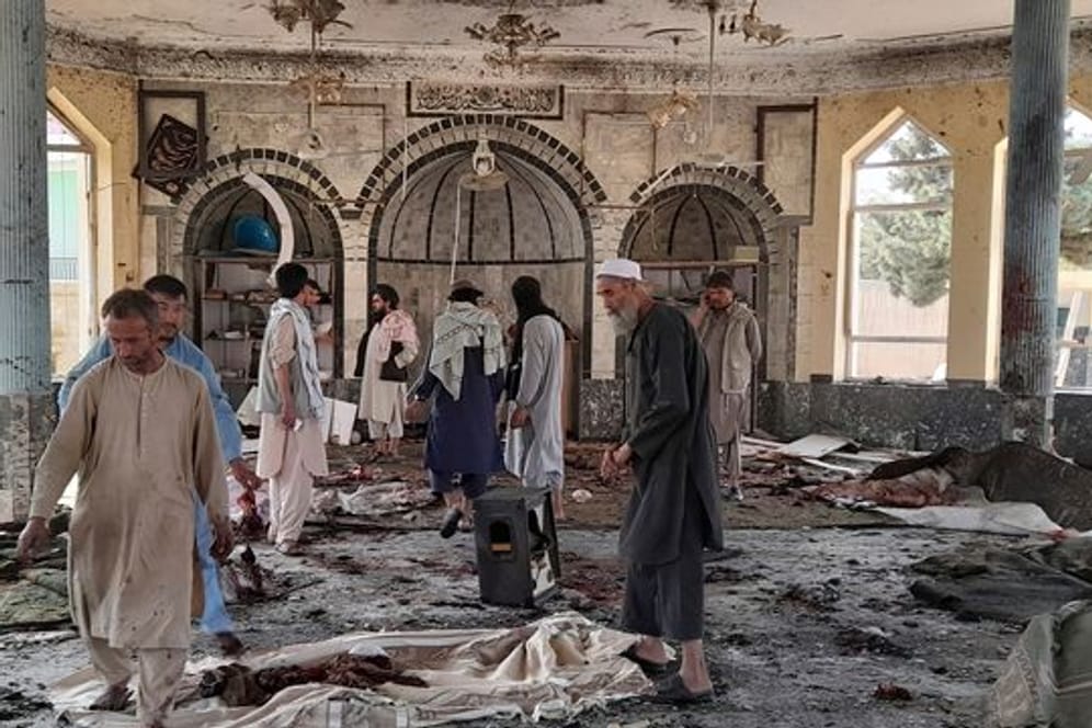 Menschen betrachten die Schäden in der attackierten Moschee in Kundus.