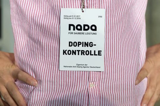 Ein Mitarbeiter der Nationalen Anti Doping Agentur (NADA) trägt einen Ausweis mit der Aufschrift "Dopingkontrolle" um den Hals.