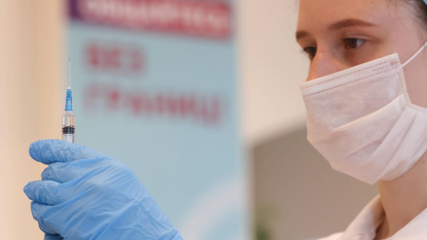 Eine Krankenpflegerin zieht eine Spritze mit Impfstoff auf (Symbolbild). In Deutschland ist die Sieben-Tage-Inzidenz leicht angestiegen.