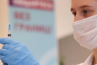 Eine Krankenpflegerin zieht eine Spritze mit Impfstoff auf (Symbolbild). In Deutschland ist die Sieben-Tage-Inzidenz leicht angestiegen.