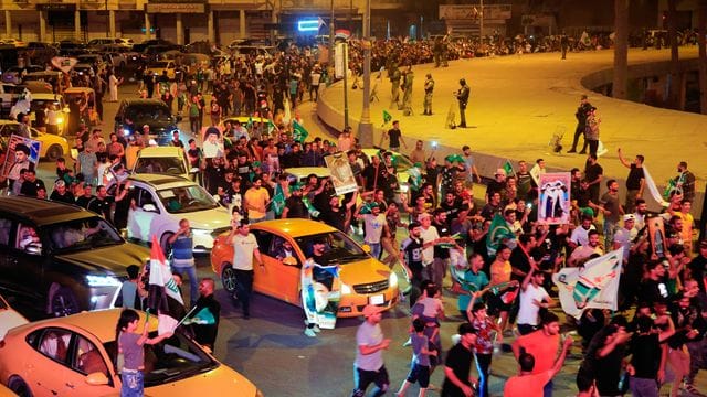 Anhänger des schiitischen Klerikers Al-Sadr feiern mit seinen Plakaten nach der Bekanntgabe der Ergebnisse der Parlamentswahlen auf dem Tahrir-Platz in Bagdad. Anhänger des schiitischen Klerikers Al-Sadr feiern mit seinen Plakaten nach der Bekanntgabe der Ergebnisse der Parlamentswahlen auf dem Tahrir-Platz in Bagdad.