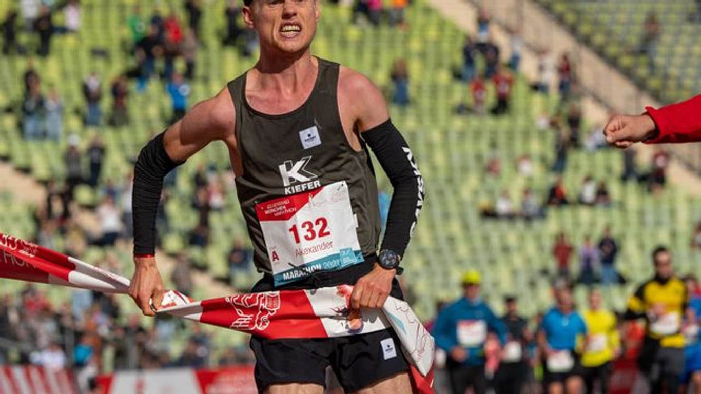 Alexander Hirschhäuser läuft beim München Marathon 2021 als erster durchs Ziel im Olympiastadion.